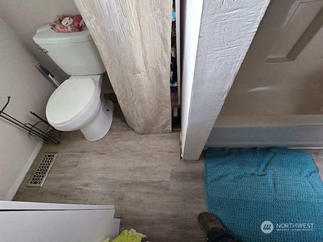 bathroom with hardwood / wood-style flooring and toilet