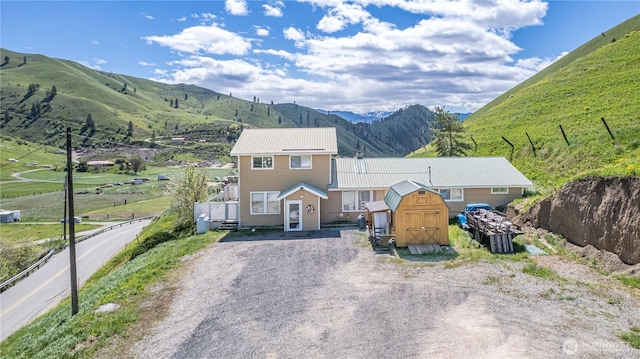 7300 Nahahum Canyon Rd, Cashmere, WA 98815 - view of front of house with gravel driveway, a shed, an outbuilding, a mountain view, and metal roof
