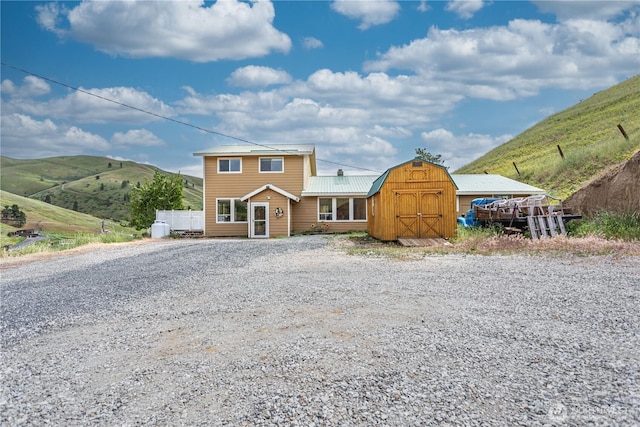 7300 Nahahum Canyon Rd, Cashmere, WA 98815 - view of front of home featuring a storage shed, an outdoor structure, a mountain view, metal roof, and gravel driveway