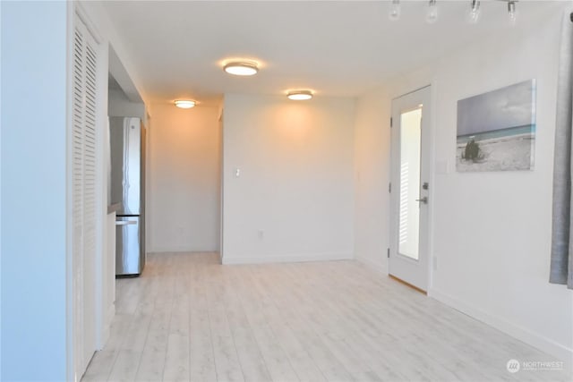 unfurnished room with light wood-type flooring