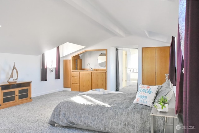 carpeted bedroom featuring sink and lofted ceiling with beams