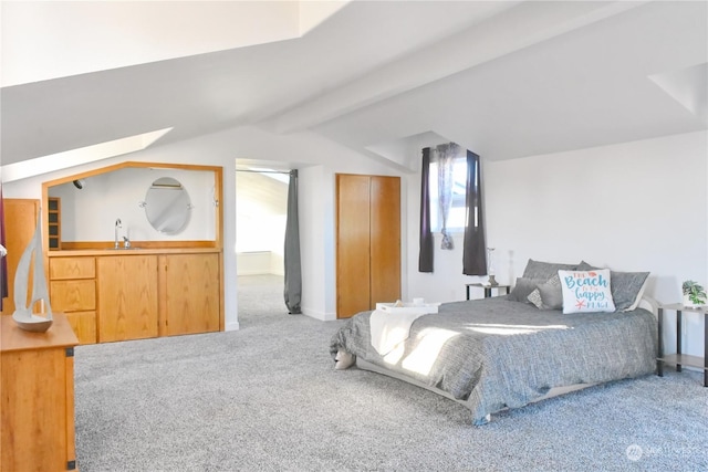 carpeted bedroom featuring sink and lofted ceiling with beams