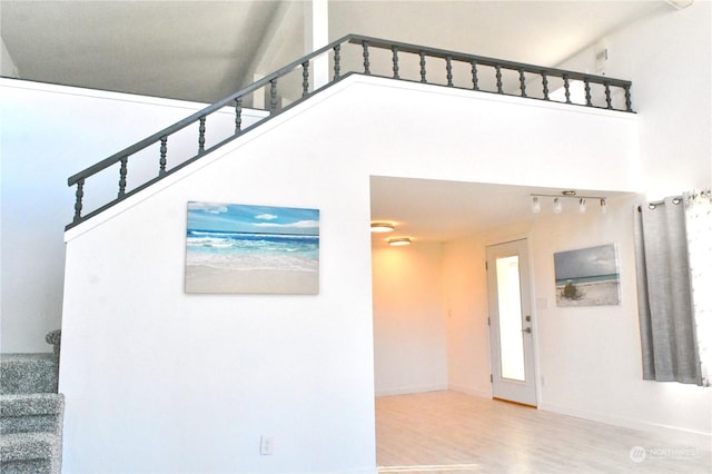 stairs with hardwood / wood-style flooring and a high ceiling