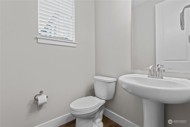 bathroom with hardwood / wood-style flooring and toilet