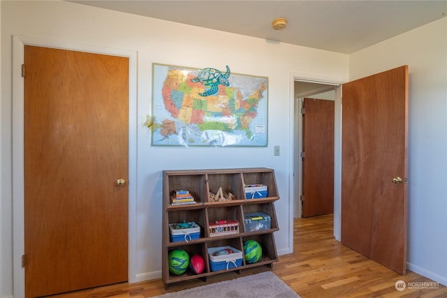 playroom with light wood-style flooring and baseboards