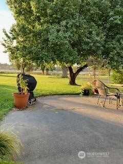 view of home's community featuring a patio area and a lawn