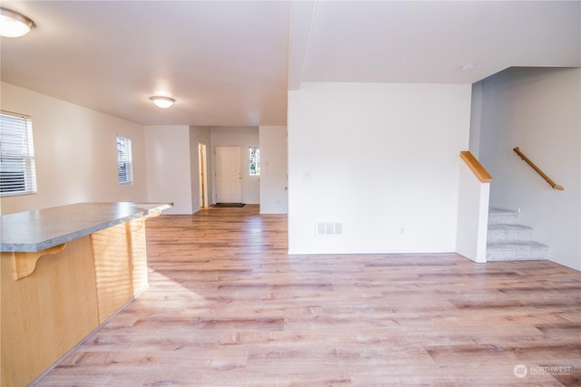 interior space with a kitchen bar and light wood-type flooring