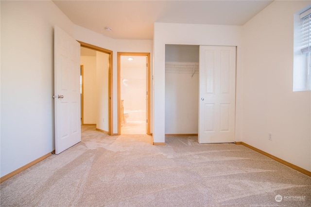 unfurnished bedroom featuring multiple windows, light colored carpet, and a closet