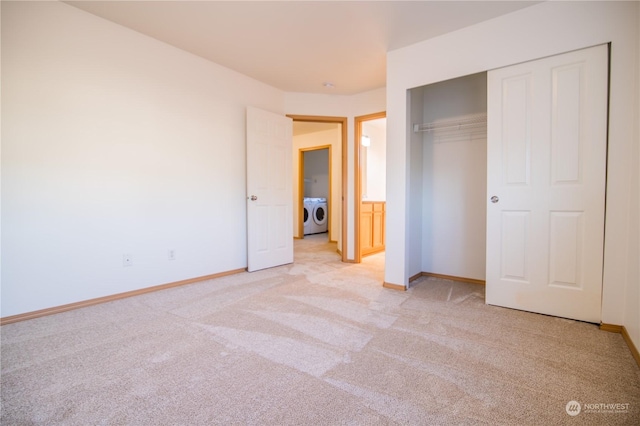 unfurnished bedroom featuring washer and dryer, light colored carpet, and a closet