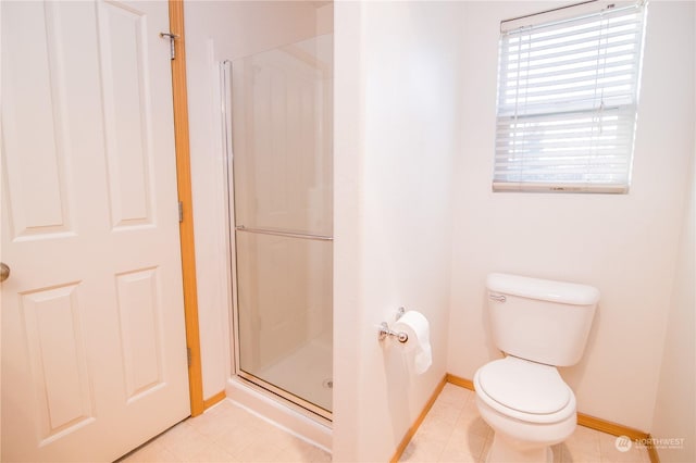 bathroom featuring a shower with shower door and toilet