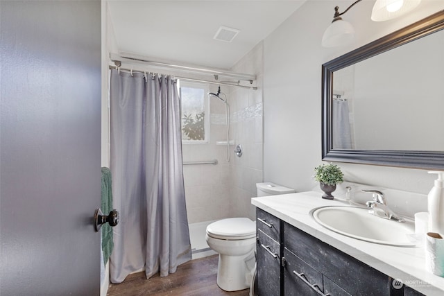 bathroom featuring wood-type flooring, a shower with shower curtain, vanity, and toilet