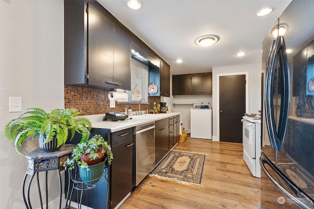 kitchen featuring dishwasher, washer / dryer, sink, white range with electric cooktop, and black fridge