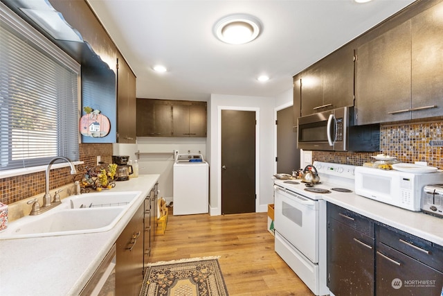 kitchen with sink, white appliances, washer / clothes dryer, decorative backsplash, and light wood-type flooring