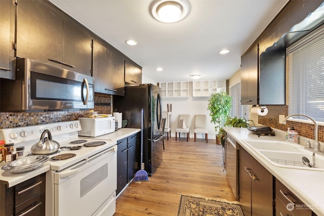 kitchen featuring appliances with stainless steel finishes, light hardwood / wood-style floors, sink, and decorative backsplash