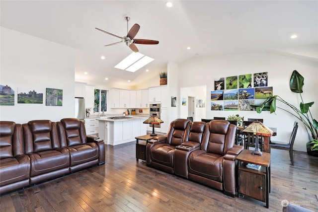 living room with ceiling fan, dark hardwood / wood-style floors, and vaulted ceiling with skylight