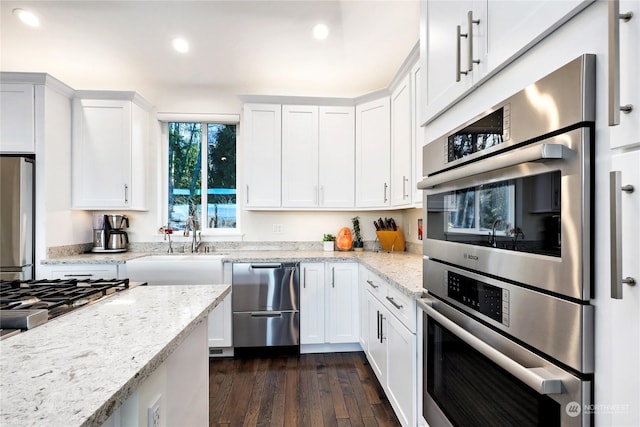 kitchen with white cabinetry, fridge, and double oven