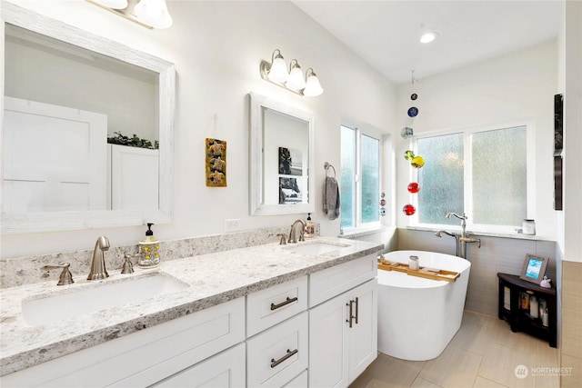 bathroom with vanity, a bath, and tile patterned flooring