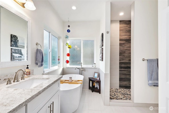 bathroom featuring tile patterned floors, vanity, and plus walk in shower