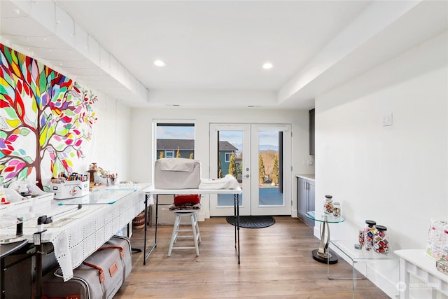 home office featuring a raised ceiling, wood-type flooring, and french doors