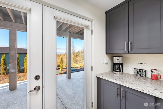 interior space featuring light stone countertops, a healthy amount of sunlight, and gray cabinetry