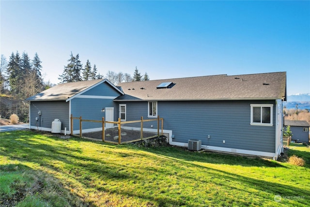 rear view of house with a yard and central air condition unit