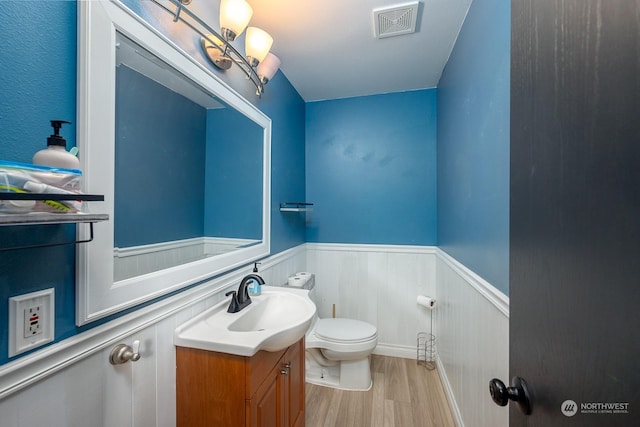 bathroom featuring vanity, hardwood / wood-style floors, and toilet