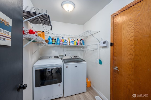 laundry area featuring separate washer and dryer and light wood-type flooring