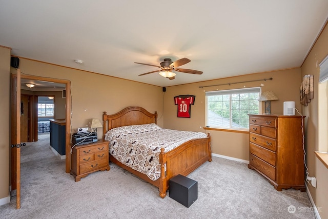 carpeted bedroom featuring multiple windows and ceiling fan