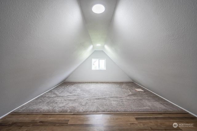 additional living space with lofted ceiling and hardwood / wood-style floors