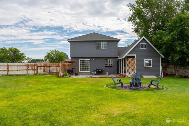 rear view of house with an outdoor fire pit, a patio, and a lawn