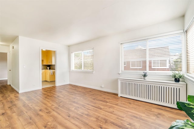 empty room featuring radiator and light hardwood / wood-style floors