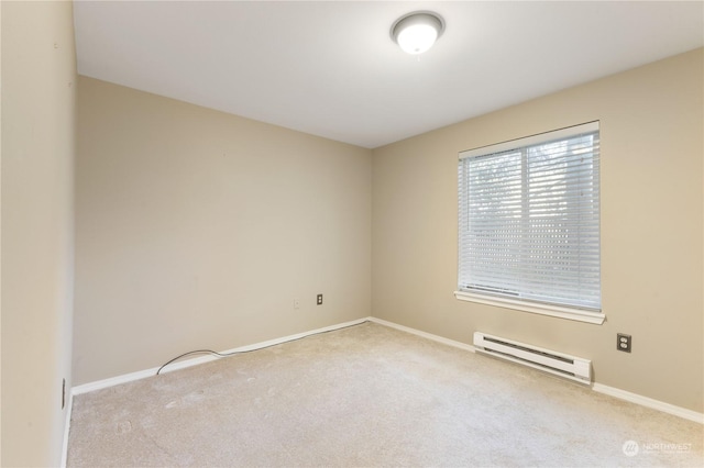 carpeted spare room featuring a baseboard heating unit