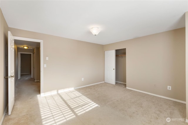 unfurnished bedroom with light colored carpet and a closet