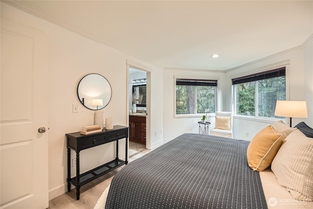 bedroom featuring baseboards, ornamental molding, and ensuite bathroom