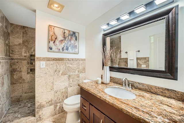 full bathroom with toilet, walk in shower, tile walls, and vanity