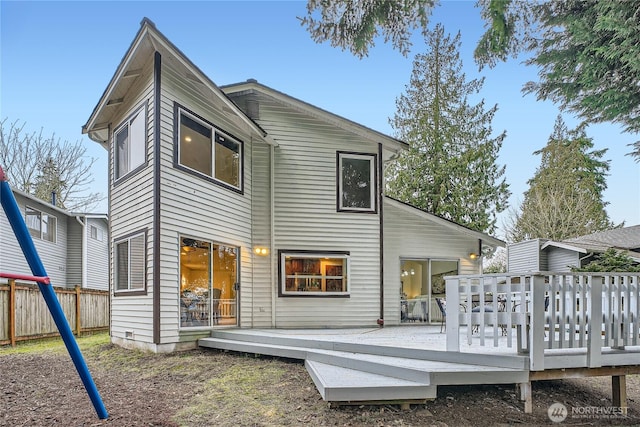 back of house featuring fence and a deck