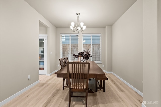 dining room with light hardwood / wood-style flooring and a chandelier