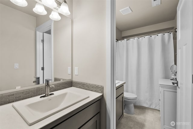 bathroom featuring vanity, toilet, and backsplash