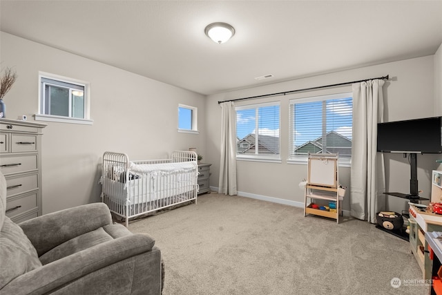 carpeted bedroom featuring a crib