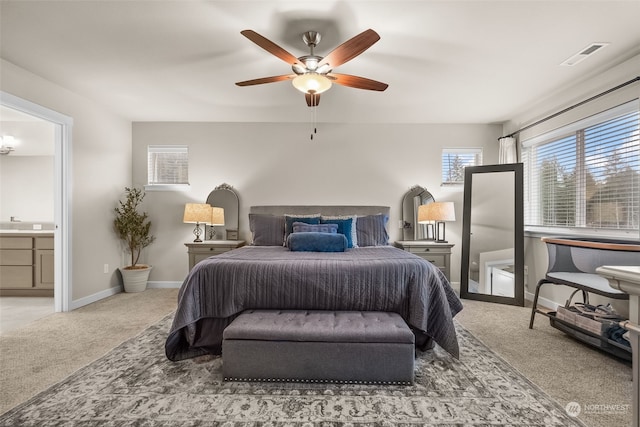 bedroom with ceiling fan, ensuite bathroom, and carpet flooring