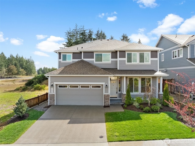 view of front of property with fence, stone siding, concrete driveway, a garage, and a front lawn