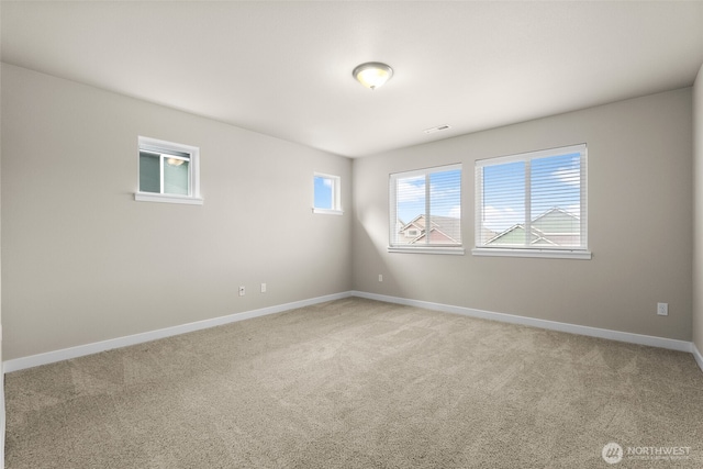 spare room featuring light carpet, baseboards, and visible vents