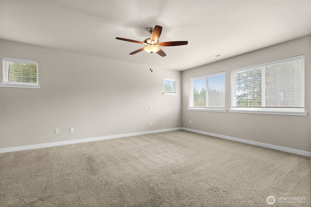 unfurnished room featuring light colored carpet, baseboards, a ceiling fan, and visible vents