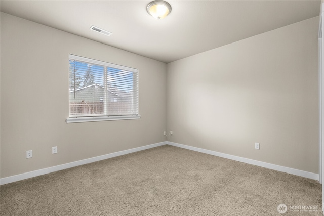 carpeted empty room featuring visible vents and baseboards
