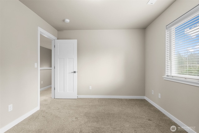 unfurnished room featuring baseboards and carpet