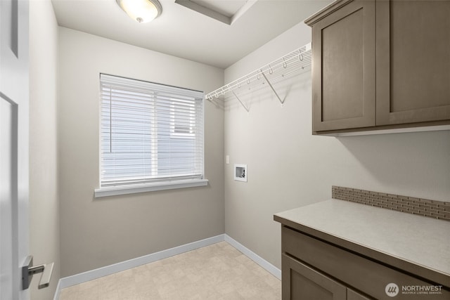 laundry area with cabinet space, washer hookup, light floors, and baseboards
