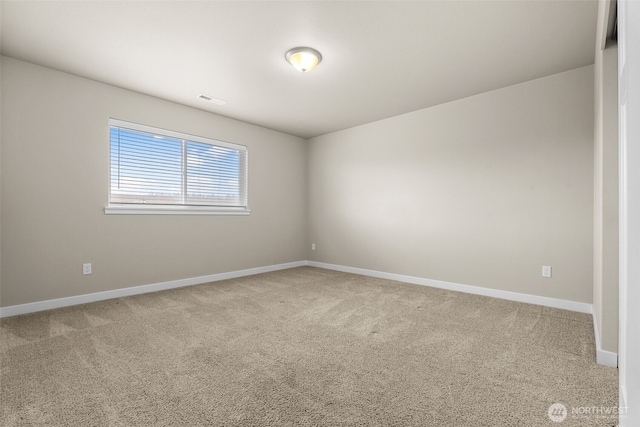 spare room featuring carpet floors, baseboards, and visible vents