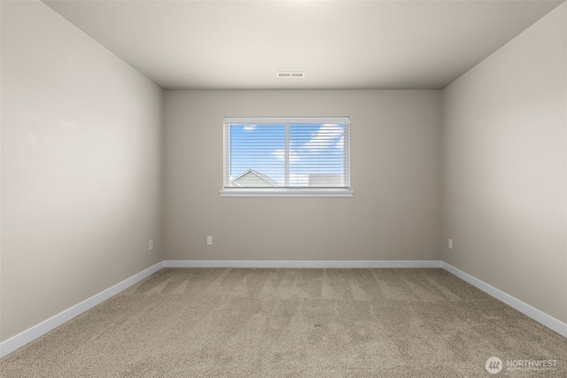 empty room featuring light colored carpet, baseboards, and visible vents