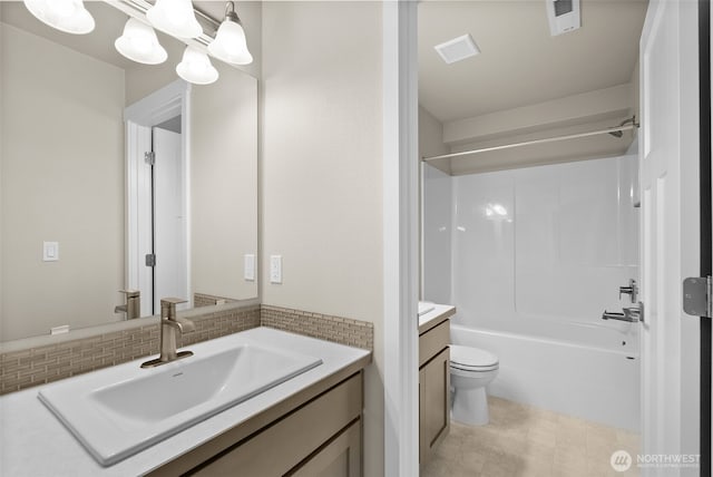 bathroom with toilet, visible vents, vanity, tub / shower combination, and decorative backsplash