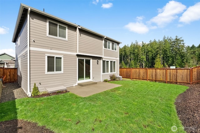 rear view of house featuring a yard, a fenced backyard, and a patio